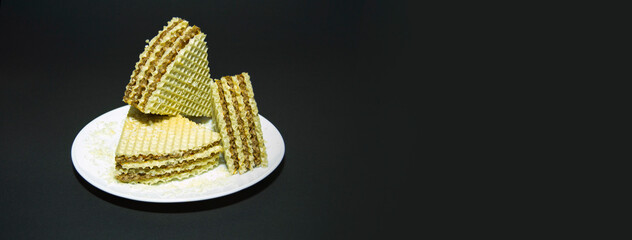 waffle cake on a white plate. black background. plate on black waffle towel. Banner for insertion into site. Place for text cope space. Horizontal image