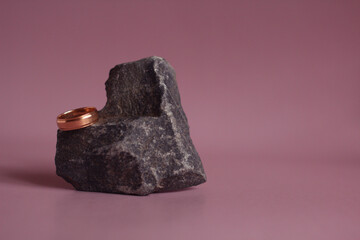 wedding ring with a heart-shaped stone on a pink background