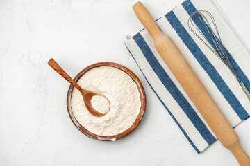 Pile of flour in wooden spoon on white background