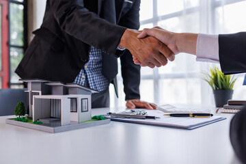 Handshake Real estate brokerage agent Deliver a sample of a model house to the customer, mortgage loan agreement Making lease and buy and sell house And contract home insurance mortgage loan concept