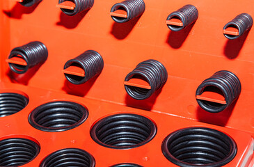 New rubber o-rings are stacked in a box, close-up.