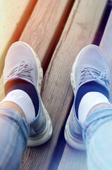 Sports shoes with short socks and jeans on a man. Sport. Summer. wooden background
