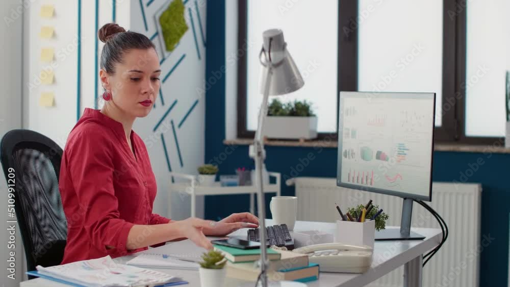 Poster sales consultant checking text message on smartphone, taking break from work on computer. office emp
