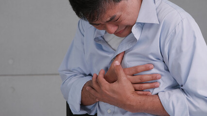 Asian man has chest pain caused by heart disease.