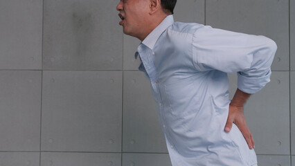 Asian old man back pain after lifting heavy object.