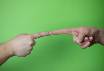 A man making hand signals on green background.