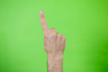 A man making hand signals on green background.