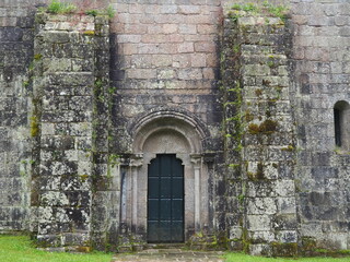 portada sur entre dos imponentes columnas, doble arquivolta apoyadas sobre capiteles vegetales, tímpano liso, iglesia de santa maría de mezonzo, la coruña, españa, europa