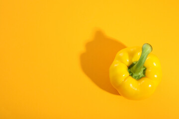 Yellow bell pepper on yellow background, space for text