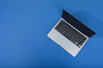 Open laptop on blue background, space for text