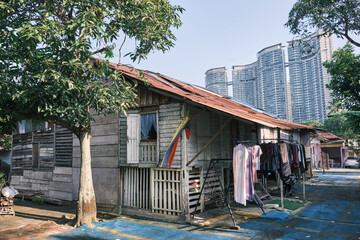 Overall view of old wooden houses with modern buildings in the background at Kampung Baru in Kuala Lumpur Malaysia.