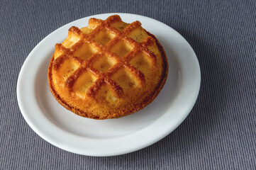 cupcake with decorated top on a plate on a tablecloth