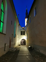 Fototapeta premium Arched passage on one of the narrow streets of Old Tallinn against the blue sky. Spring evening.