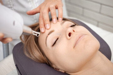 cosmetologist removes permanent makeup, eyebrow tattooing with laser - obrazy, fototapety, plakaty