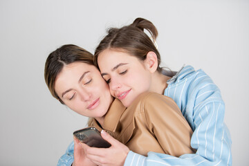 Lesbians lgbt couple. Portrait of two cheerful young women with mobile phone, smartphone. Two...