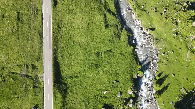 A view from above at a car passing buy a mountain river on Klausenpass in Switzerland