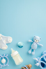Baby boy concept. Top view vertical photo of milk bottle tiny socks knitted teddy bear toy blue...