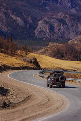 Travel road with car 4x4 mountains Altai with snow hill and autumn forest © Parilov
