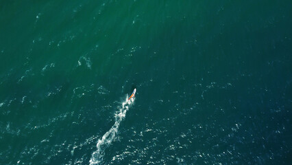Aerial drone view of windsurfer enjoying on blue sea ocean waves..