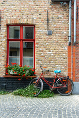 Fototapeta na wymiar Belgium Bike against brick wall with flowers