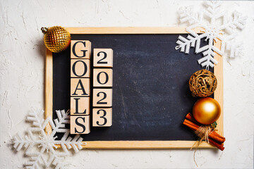 Goals 2023 black writing board, wooden cubes with inscription. Copy space in the center. Christmas...