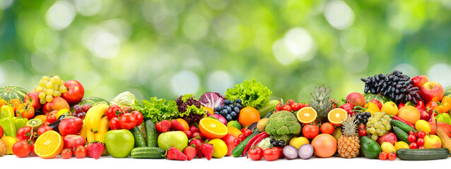 Wide horizontal seamless pattern of vegetables and fruits on green