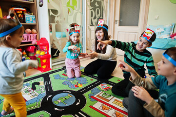 Obraz na płótnie Canvas Happy family with four kids playing game guess who while having fun at home.