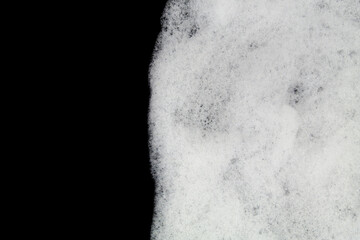 White foam bubbles on black background with space for text.