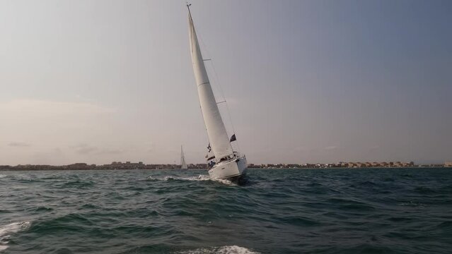 Front view of sailboat sailing in slow motion over the city