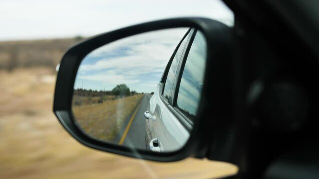 A rearview mirror through which you can see the road and the surroundings. Filmed while driving from the car.