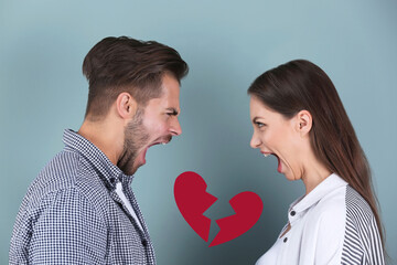 Young couple having argument and illustration of broken heart on color background. Relationship...