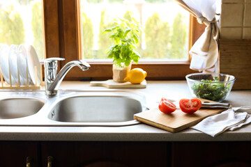 Cut fresh tomato near sink in kitchen