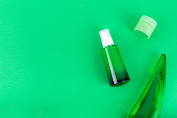 moisturizes serum, jar of cream on green background. Moisturizing beauty product with organic. Body care lotion. Simple empty packaging beauty cosmetics. Mock up, copy space