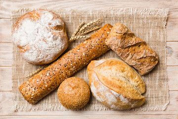 Assortment of freshly baked bread with napkin on rustic table top view. Healthy unleavened bread. French bread
