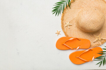 Summer travel concept. Flip flops, summer hat and starfish on white. Top view on colored background