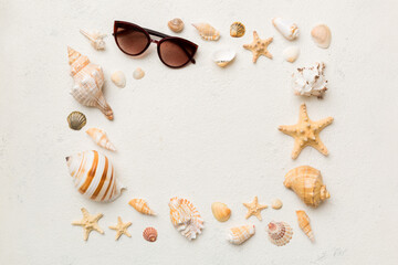 Summer time concept on colored background. Seashells from ocean shore in the shape of frame separated with space for text top view