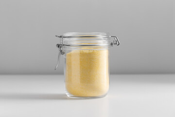 food, eating and cooking concept - jar with corn flour on white background