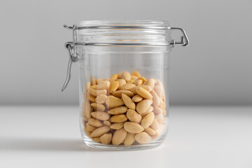 food, healthy eating and diet concept - jar with almonds on white background