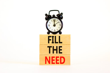 Fill the need symbol. Concept words Fill the need on wooden blocks on a beautiful white table white background. Black alarm clock. Business, finacial and fill the need concept. Copy space.