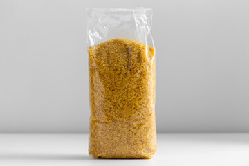 food, healthy eating and diet concept - bag with bulgur on white background