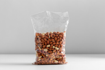 food, healthy eating and diet concept - bag with raw peanuts on white background