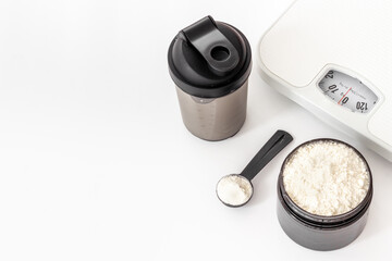 Whey protein powder in jar and scales. Fitness and gym food diet
