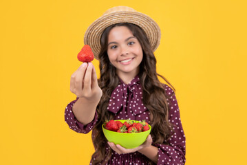 selective focus of happy teen kid hold strawberry bowl on yellow background