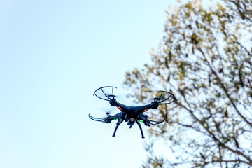 Drone camera quad copter flying in the sky with trees. Drone photography videography aerial wireless technology