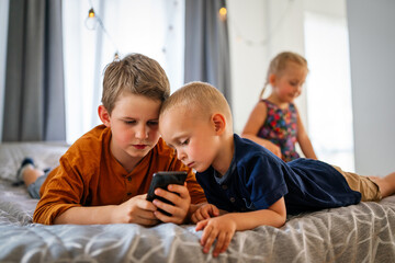 Portrait of happy children using digital devices and having fun together.