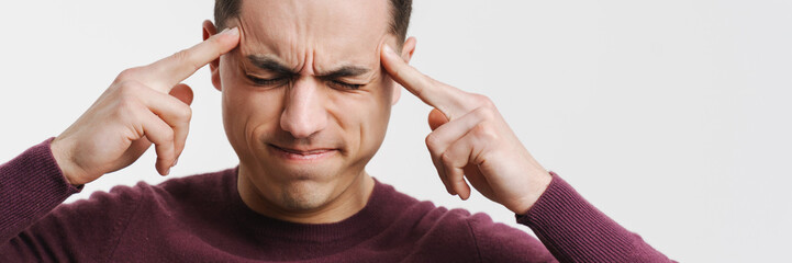 Obraz premium Young brunette man with headache rubbing his temples