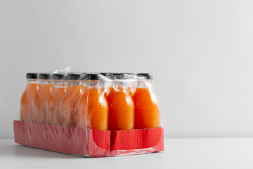 healthy eating, drinks and packaging concept - close up of pack of glass bottles with fruit or vegetable juice
