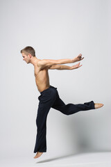 Obraz premium modern ballet male dancer posing over white studio background