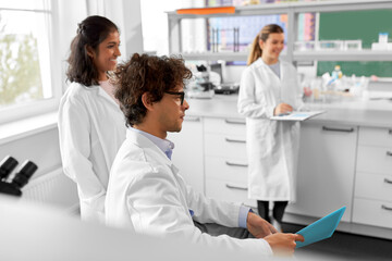 Fototapeta premium science, work and people concept - international group of happy scientists in laboratory