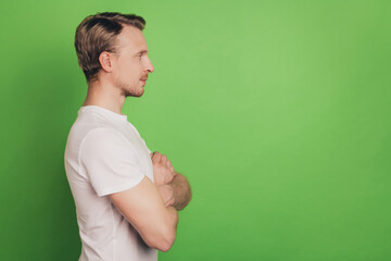 Profile view photo of self-assured strong virile man folded arms blank space isolated on green...